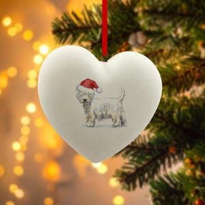 Può includere: Ornamento natalizio a forma di cuore, bianco, con un'illustrazione ad acquerello di un Westie con un cappello da Babbo Natale. Appeso a un nastro rosso, perfetto per le decorazioni natalizie.