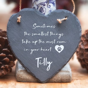 Może przedstawiać: Czarna, sercowata tabliczka ze łupka z tekstem "Sometimes the smallest things take up the most room in your heart" i ikoną odcisku łapy. Nazwa "Tilly" jest napisana pod tekstem.