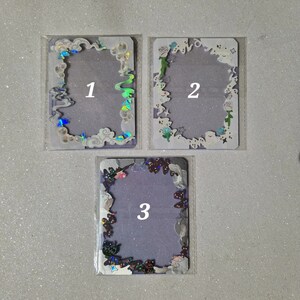 Puede incluir: Tres marcos de plástico transparente con purpurina iridiscente y diseños variados. Los marcos están numerados del 1 al 3.