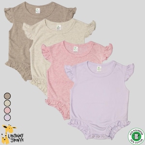May include: Four baby bodysuits in neutral colors: tan, cream, pink, and lavender. Each has ruffled sleeves and a ruffled bottom. The bodysuits are made of a blend of 65% polyester and 35% cotton. The brand logo "Laughing Giraffe" is visible.