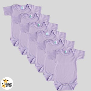 May include: Five lavender short-sleeved baby onesies with a white tag that says "Laughing Giraffe" on each one.