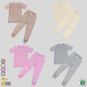May include: Four sets of children's pajamas in different colors. The pajamas are made of a soft, comfortable fabric and are perfect for sleeping or lounging around the house. The pajamas are available in beige, pink, gray, and white.