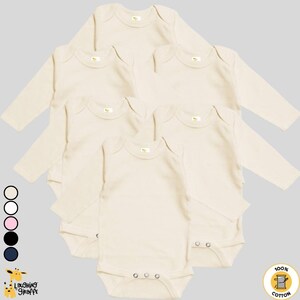 May include: Five long-sleeved, cream-colored baby onesies with snap closures. The onesies are made of 100% cotton and feature a small tag with the words "Laughing Giraffe" on the bottom left corner.