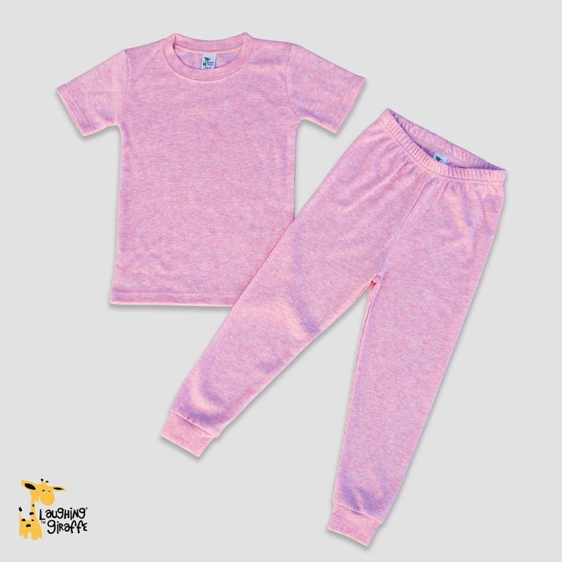 May include: A pink two-piece pajama set for children. The set includes a short-sleeved t-shirt and matching pants.
