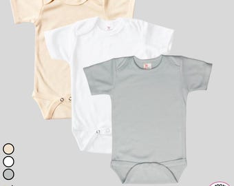 May include: Three short-sleeved baby onesies in beige, white, and light gray. The onesies are made of 100% polyester.