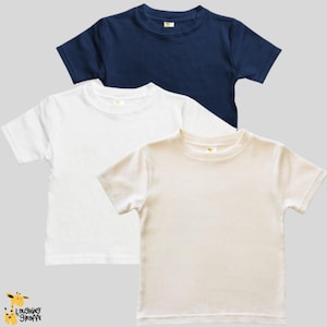 May include: Three plain t-shirts in navy blue, white, and cream. The shirts are folded and stacked on top of each other.