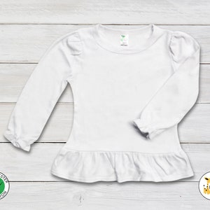 May include: White long-sleeve shirt with a ruffle at the bottom and puffed sleeves. The shirt is made of 65% polyester and 35% cotton.