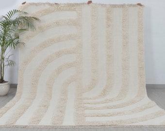May include: A white, fluffy rug with a geometric pattern of curved lines. The rug has a fringe border.