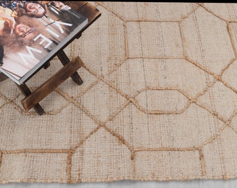 May include: A natural fiber rug with a geometric pattern in a light beige color. The rug has a woven texture and is made of jute.