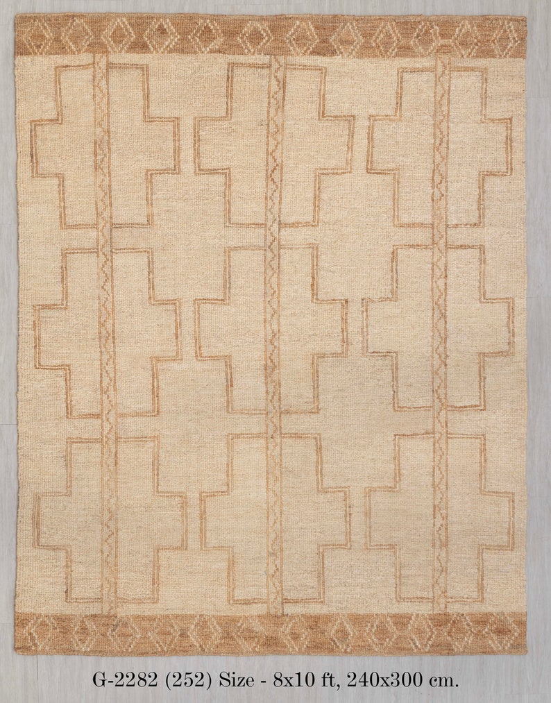 May include: A beige rug with a geometric pattern of brown crosses. The rug has a brown border with a diamond pattern. The rug is 8x10 feet, or 240x300 cm. G-2282 (252)