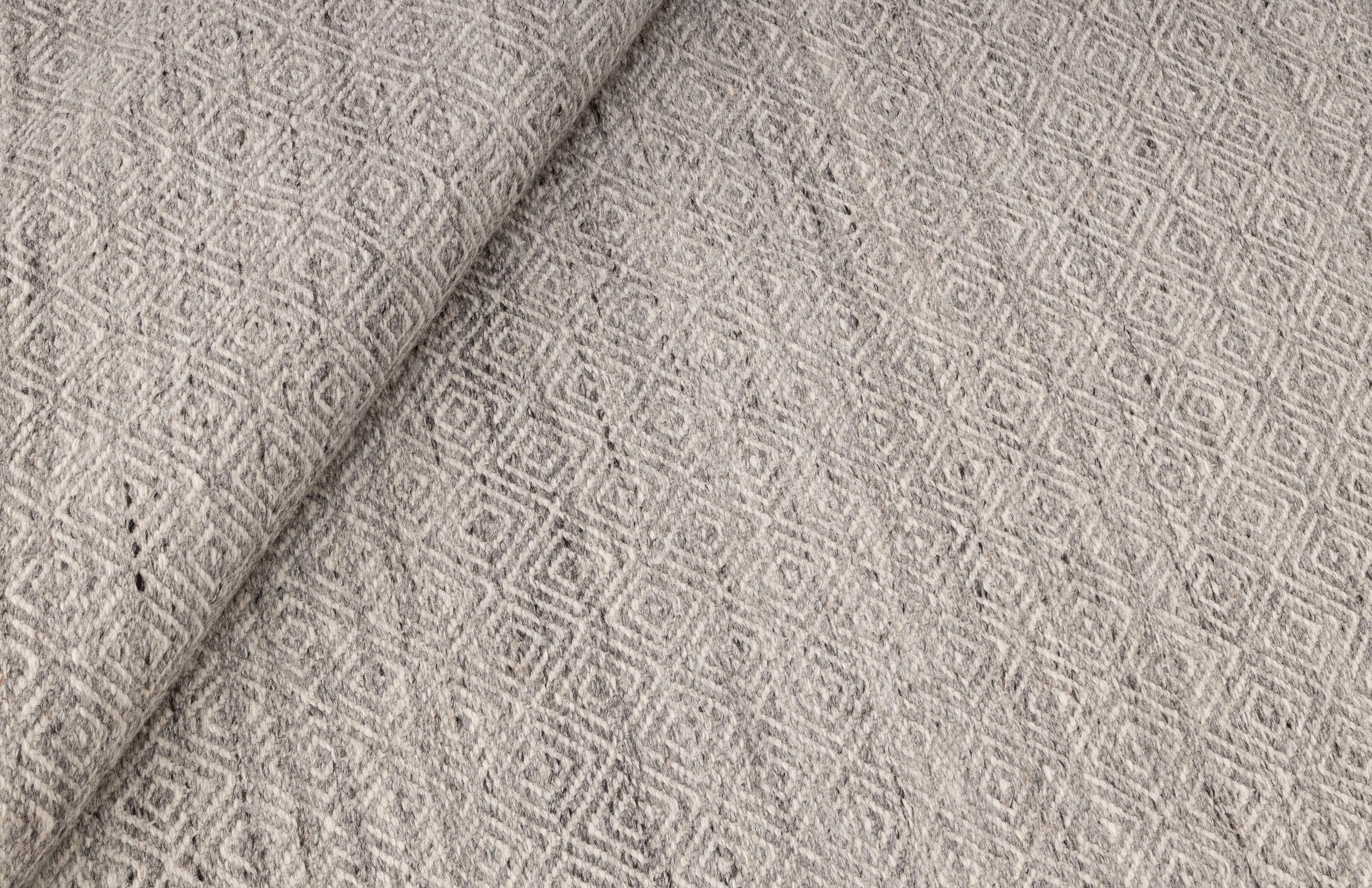 グレーアイボリーのモダンな幾何学模様の手織りウール平織りラグ