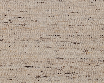 Puede incluir: Primer plano de una alfombra tejida en color beige y blanco. La alfombra tiene una superficie texturizada con un patrón sutil.