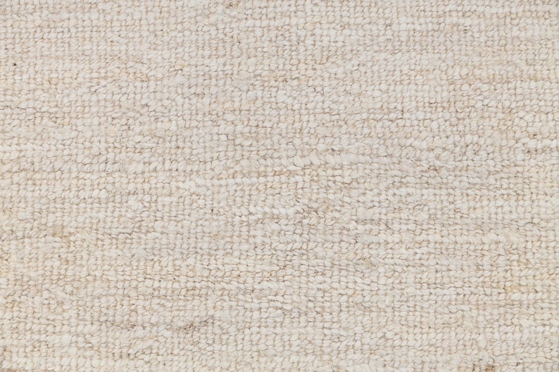 May include: Close-up of a white, textured fabric with a woven pattern. The fabric has a soft, fuzzy texture.