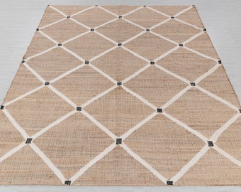 May include: A natural fiber rug with a diamond pattern in white and black. The rug has a woven texture and is made of jute.