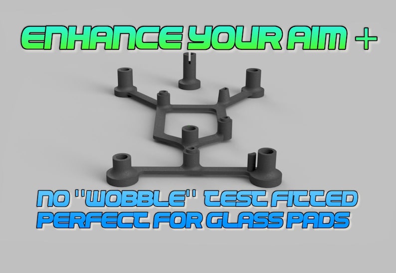 May include: A dark gray, multi-pronged plastic frame with several cylindrical mounting points. The text ENHANCE YOUR AIM + appears at the top, and the text NO "WOBBLE" TEST FITTED PERFECT FOR GLASS PADS appears at the bottom of the image.