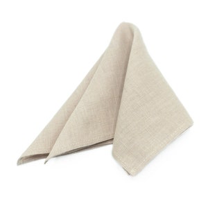 May include: A beige linen napkin folded into a triangle shape.