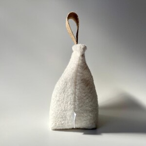 Ivory boucle fabric doorstop with jute handle.
