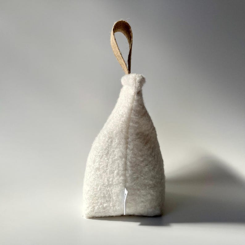 Ivory boucle fabric doorstop with jute handle.