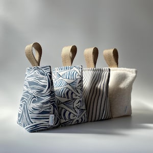 May include: Four wedge-shaped doorstops with jute handles. The first features a blue and white wave pattern, the second a blue and white fish print, the third blue and white vertical stripes, and the fourth is a solid off-white textured fabric.