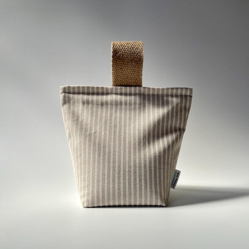 Taupe and white stripe fabric doorstop with jute handle.