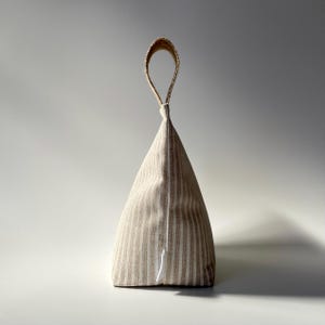 Taupe and white stripe fabric doorstop with jute handle.