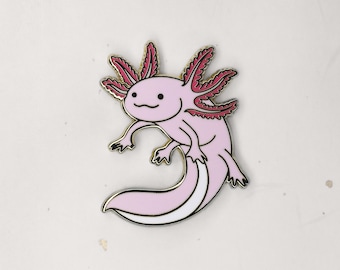 May include: A pink and red axolotl enamel pin with a white outline. The axolotl is smiling with its mouth closed and has small, black eyes. The pin is a cartoon-style illustration.