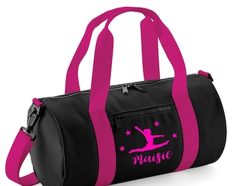 Peut inclure: Sac de sport noir avec des accents roses et une silhouette rose d'une gymnaste avec des étoiles et le nom "Maisie" imprimé sur le devant.