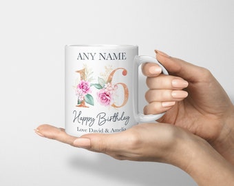 Może przedstawiać: Biały kubek ceramiczny z kwiatowym wzorem w kolorze złotym i różowym z numerem 16. Na kubku nadrukowany jest tekst "Happy Birthday" i "Love David & Amelia".