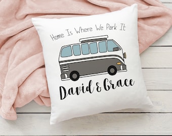 May include: White throw pillow with a black and white illustration of a vintage camper van with the text "Home Is Where We Park It" and the names "David & Grace" below the van.