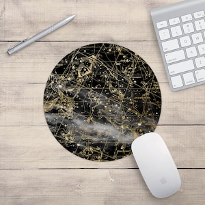 May include: A black and gold round mouse pad with a constellation map design. The constellations are outlined in gold and the background is black with a white cloudy effect.