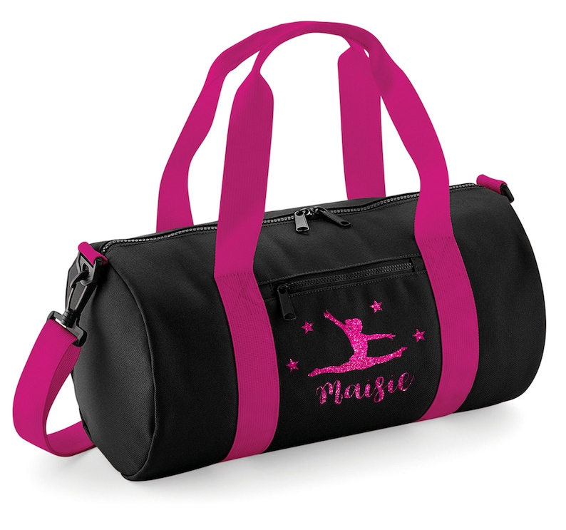 May include: Black gym bag with pink accents and a pink glitter design of a gymnast with the name Maisie.