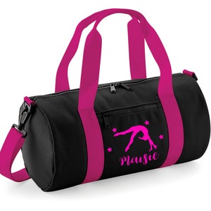 May include: Black gym bag with pink straps and a pink silhouette of a gymnast doing a back handspring. The bag has a zippered pocket on the front and the name "Maisie" is printed on the front.