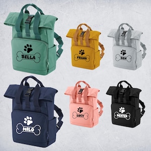 May include: Six personalized backpacks with a paw print and bone design. The backpacks are in different colors: green, yellow, gray, pink, blue, and black. The names on the backpacks are Bella, Frank, Ben, Lucy, Milo, and Dexter.