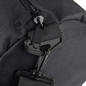 May include: Close-up of a black duffel bag with a zipper closure and a black strap with a clip. The bag is made of a durable, water-resistant material.
