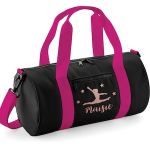 May include: Black gym bag with pink straps and a pink zipper. The bag has a pink silhouette of a gymnast with the name "Maisie" written below.
