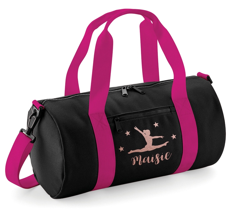 May include: Black gym bag with pink straps and a pink zipper. The bag has a pink silhouette of a gymnast with the name "Maisie" written below.