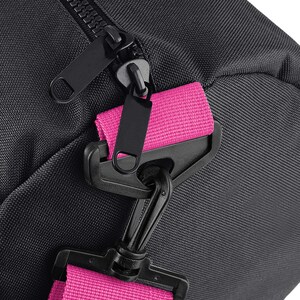 May include: Black duffel bag with a pink strap and a black zipper. The strap has a black plastic clasp.