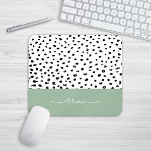 May include: A white and black leopard print mouse mat with a light green bottom border. The name "Olivia" is written in white script on the green border.