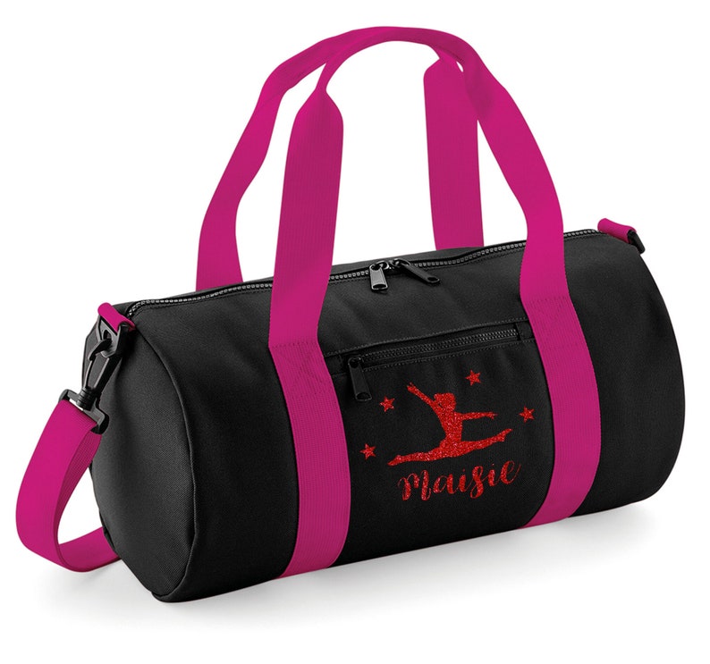 May include: Black gym bag with pink straps and a red glitter design of a gymnast with the name "Maisie" written below.