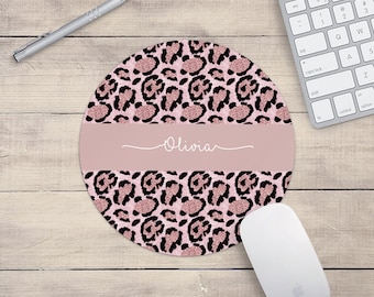 May include: Round pink and black leopard print mouse pad with the name Olivia in a cursive script.