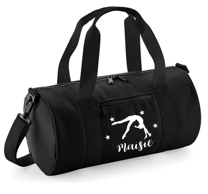 May include: Black gym bag with a white silhouette of a gymnast doing a back handspring and the name "Maisie" written below. There are five white stars around the gymnast.