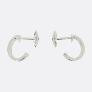 May include: A pair of silver hoop earrings with a small diamond on each hoop.