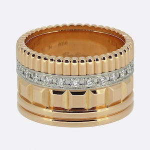 May include: A multi-band ring crafted from rose gold and white gold. The design features a top ribbed band, a central white gold band set with a row of round brilliant-cut diamonds, a middle band with a geometric pyramid pattern, and a smooth base band.