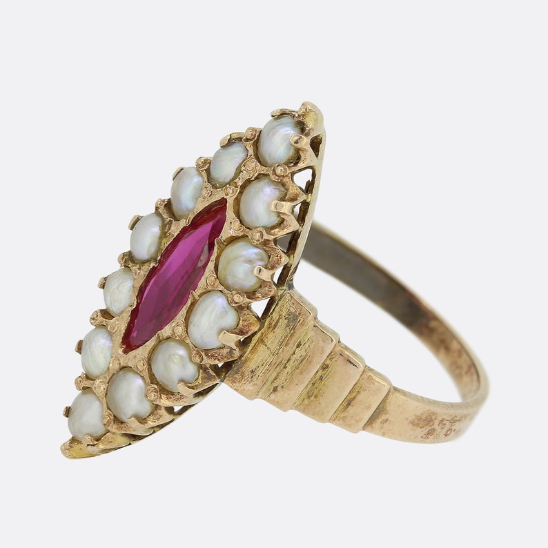 May include: A gold ring with a red ruby gemstone surrounded by a cluster of white pearls.