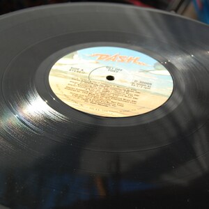 May include: Black vinyl record with a white label that says "Dash" in red letters. The label also includes the text "Side A Stereo" and "Get Off  Free" along with a list of song titles.