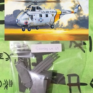 Op de afbeelding: Een grijze plastic modelkit van een Sikorsky UH-19 helikopter in een doorzichtige plastic zak. De zak ligt op een groene ondergrond met zwarte Japanse karakters. De modelkit is gelabeld "Sikorsky UH-19".