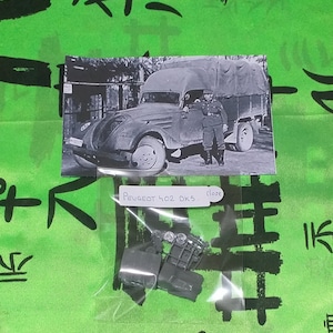 May include: A plastic bag containing a model kit of a gray Peugeot 402 DK5 truck. The bag is labeled "Peugeot 402 DK5. Close". The image also shows a black and white photo of a similar truck.