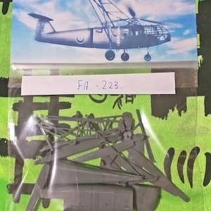 Puede incluir: Un kit de maqueta de plástico de un helicóptero gris con el texto "FA - 223." en una etiqueta blanca. El kit incluye varias piezas, incluyendo el fuselaje, las palas del rotor y el tren de aterrizaje.
