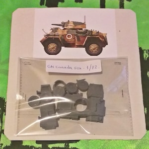 Puede incluir: Un kit de maquetas de plástico de un vehículo blindado militar a escala 1/72. El kit incluye varias piezas, incluyendo ruedas, una torreta y la carrocería del vehículo. El kit está empaquetado en una bolsa de plástico transparente con un respaldo de cartón blanco. La tarjeta tiene una imagen del modelo terminado y el texto "GH Canada Fox - 1/72."