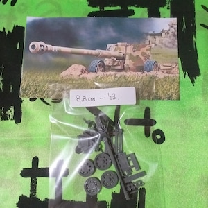 以下が含まれることがあります： ドイツ製の8.8cm Flak 43 対空砲のプラスチックモデルキット。キットには砲身、車輪、その他の部品が含まれています。キットは透明なビニール袋に入っています。